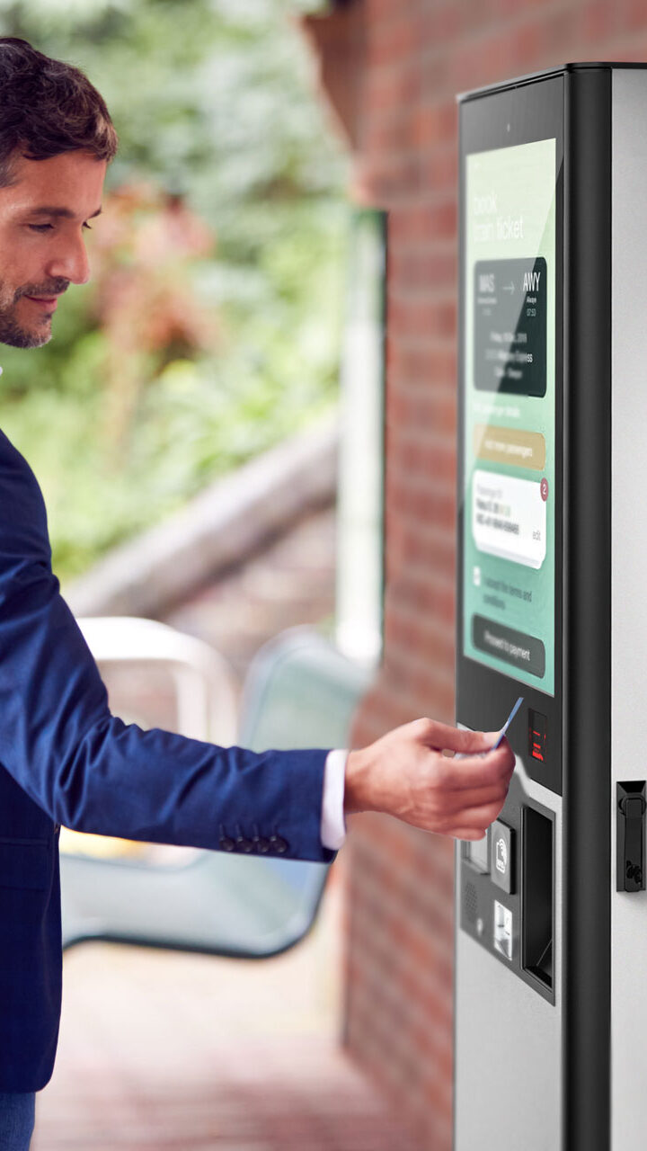 Mann nutz Outdoor für Ticketing an einem Bahnhof